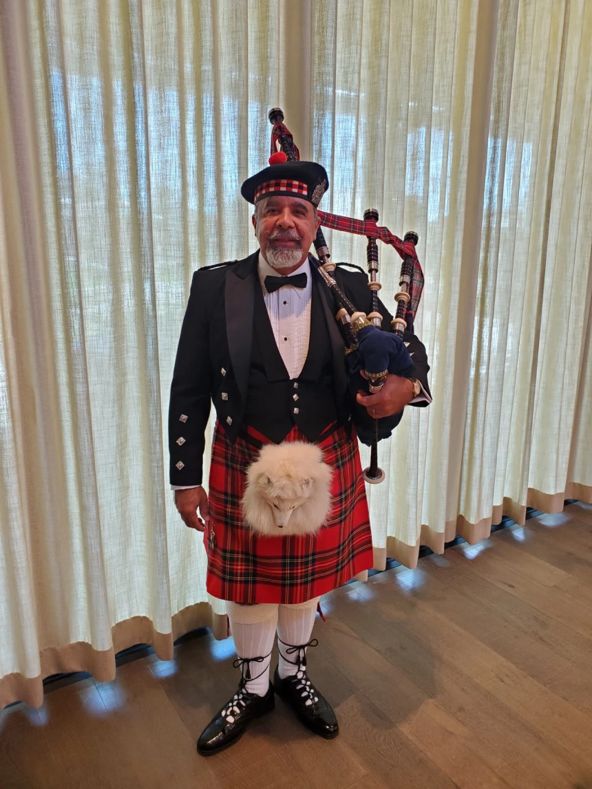 A man in a kilt and bagpipe outfit.